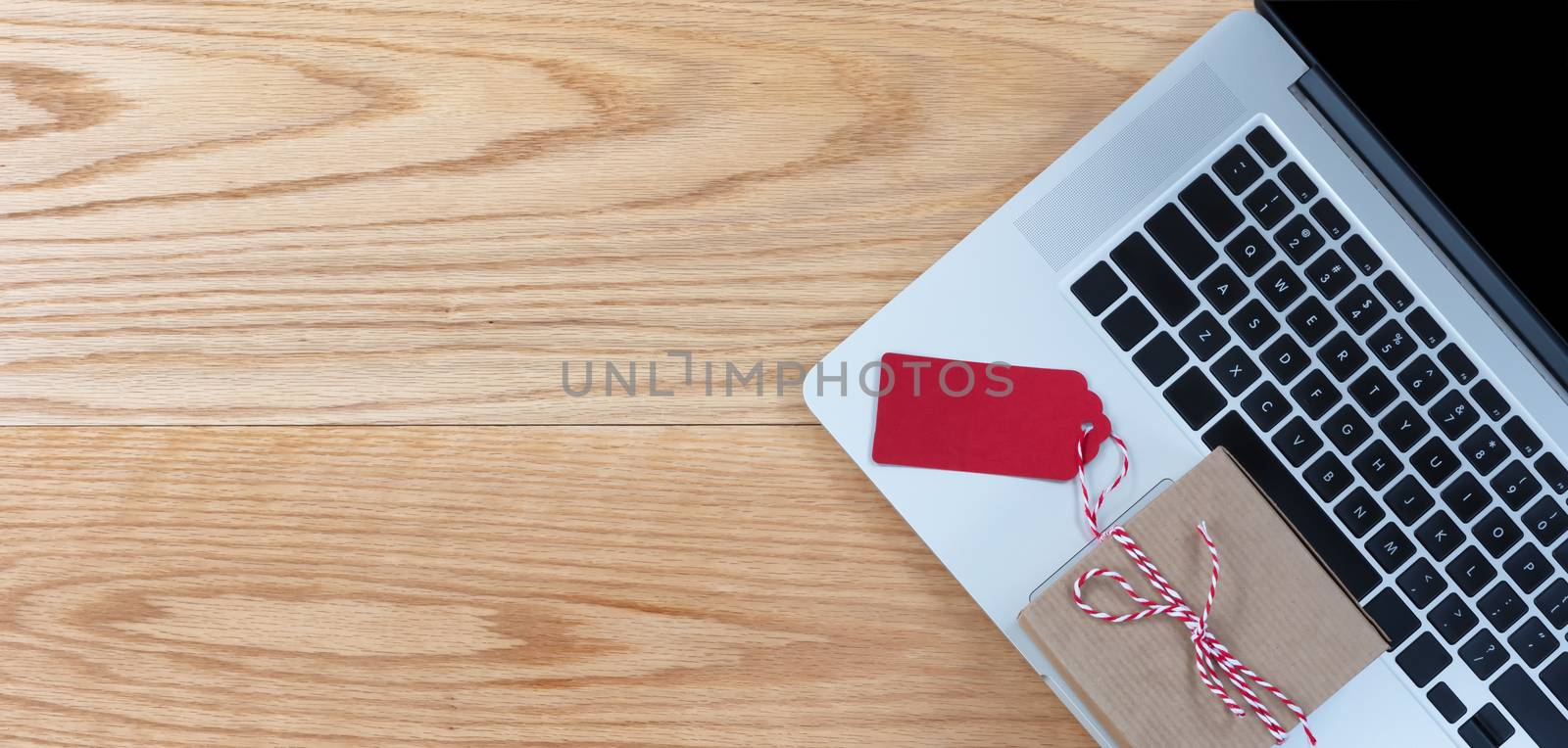 Mobile computer with gift box on wooden desktop 