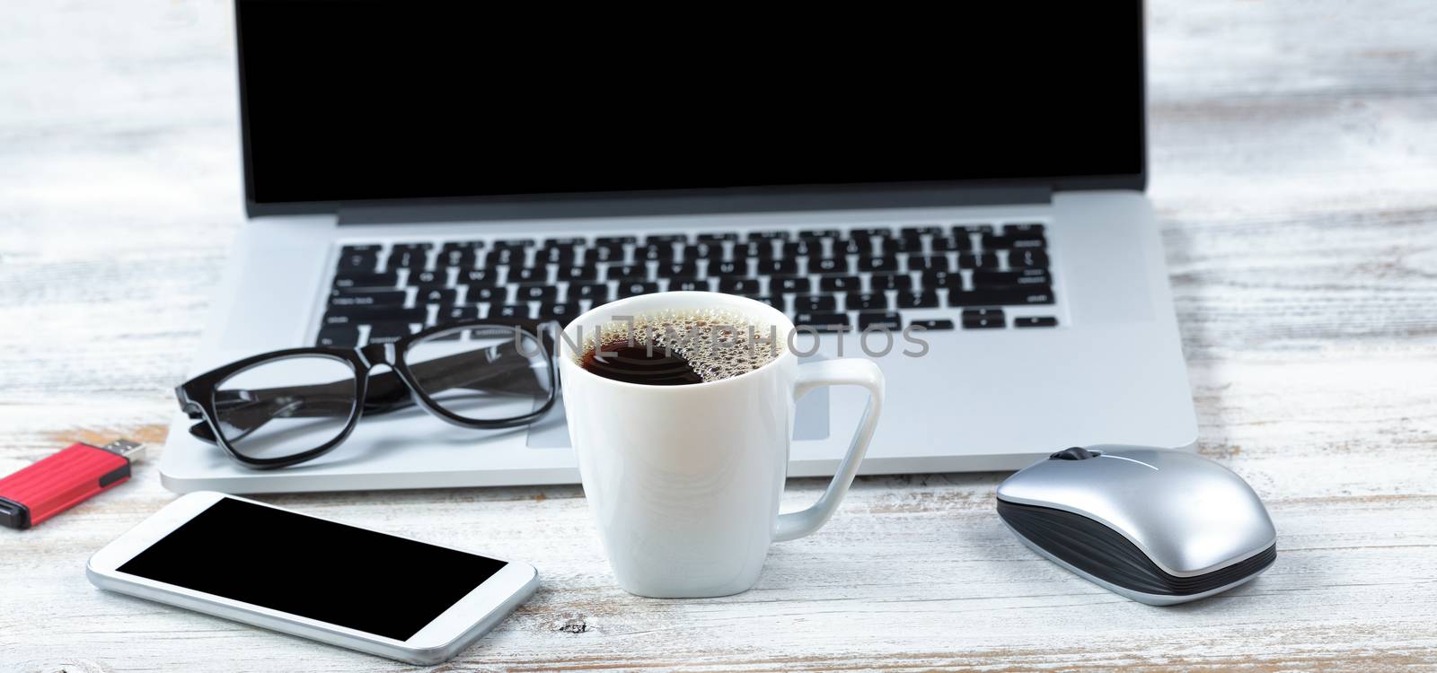 Cup of fresh coffee with workstation technology in background for business or education use 