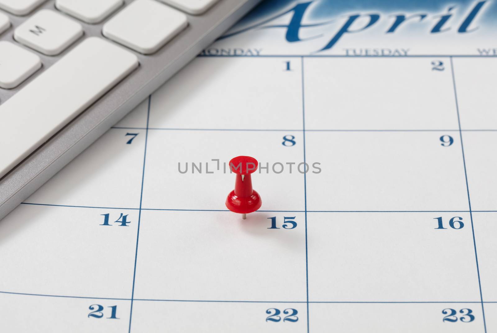 Single red pushpin on April 15 of calendar for tax income due da by tab1962