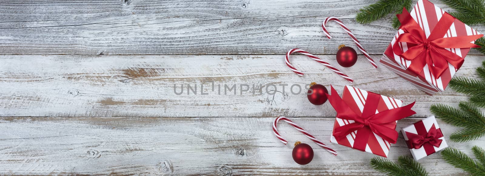Merry Christmas with right border of gifts and ornaments on white rustic wooden background for the holiday