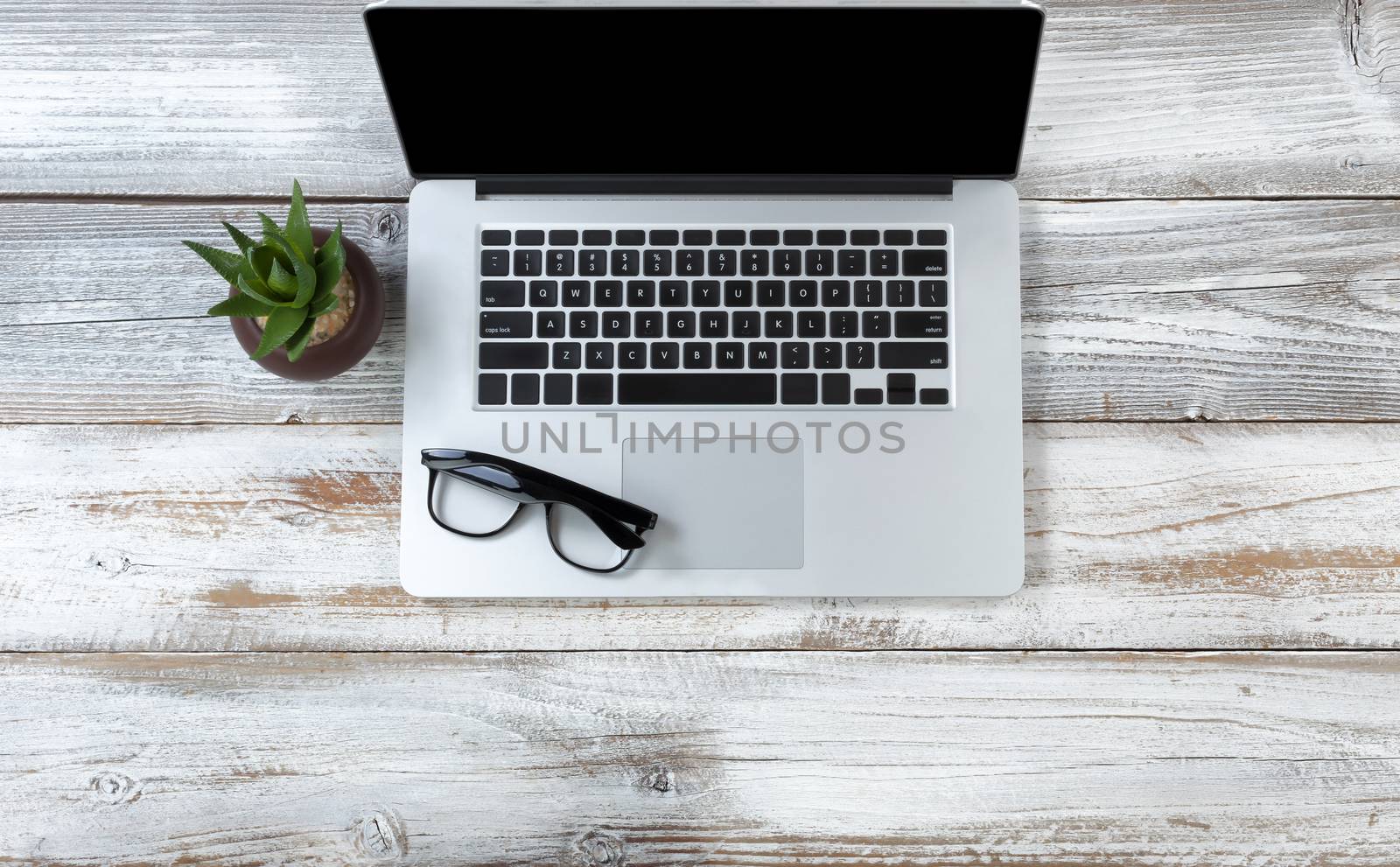 Top view of a laptop computer with reading glasses on white rust by tab1962