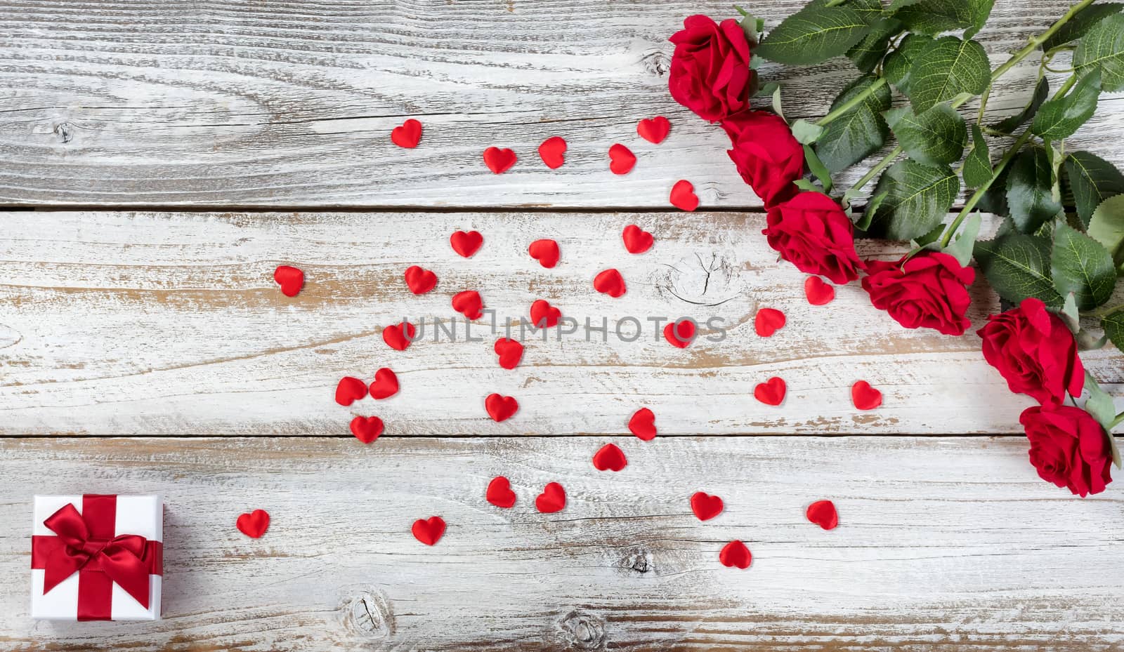 Red roses with gift and decorative hearts for Valentines Day