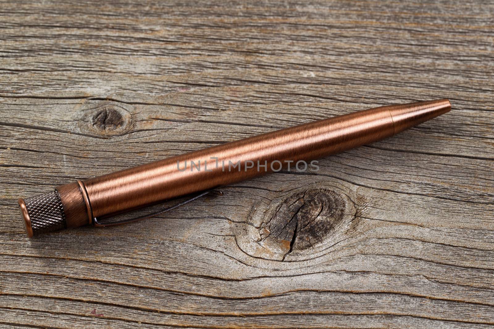 Close up of antique metal pen on weathered wood.