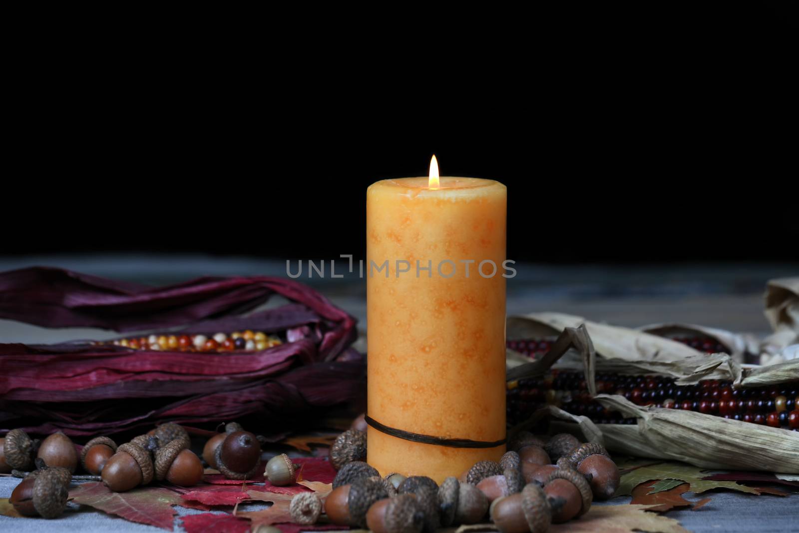 Burning candle for Thanksgiving or Halloween holidays with dark  by tab1962