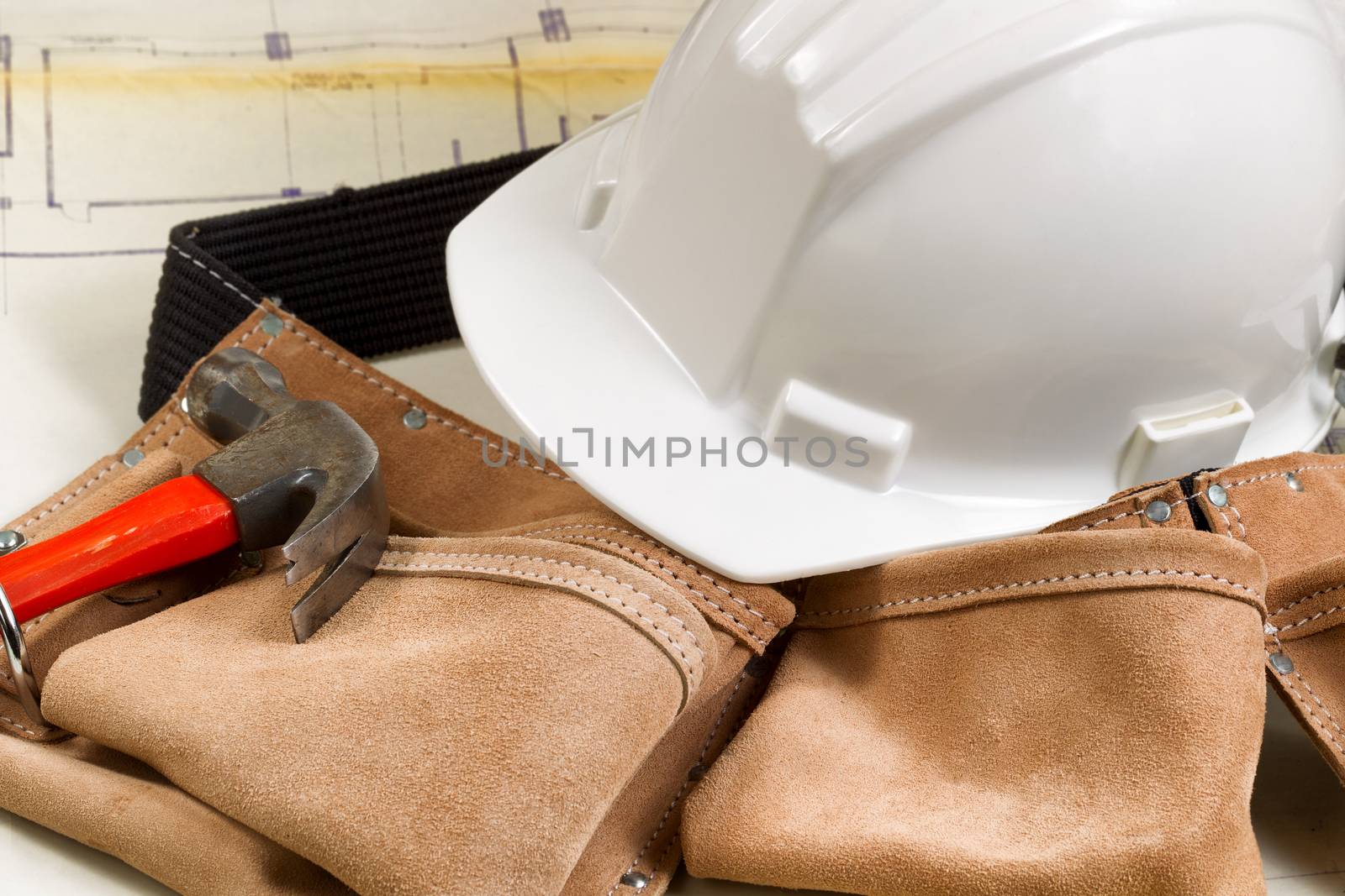 Close up of construction contractor tools with blurred out blue print drawings in background.  