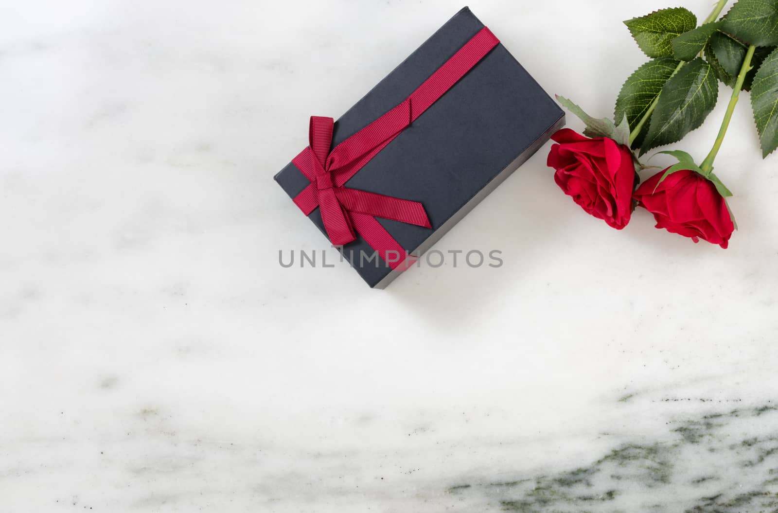 Red Roses and packaged gift box on marble stone background by tab1962