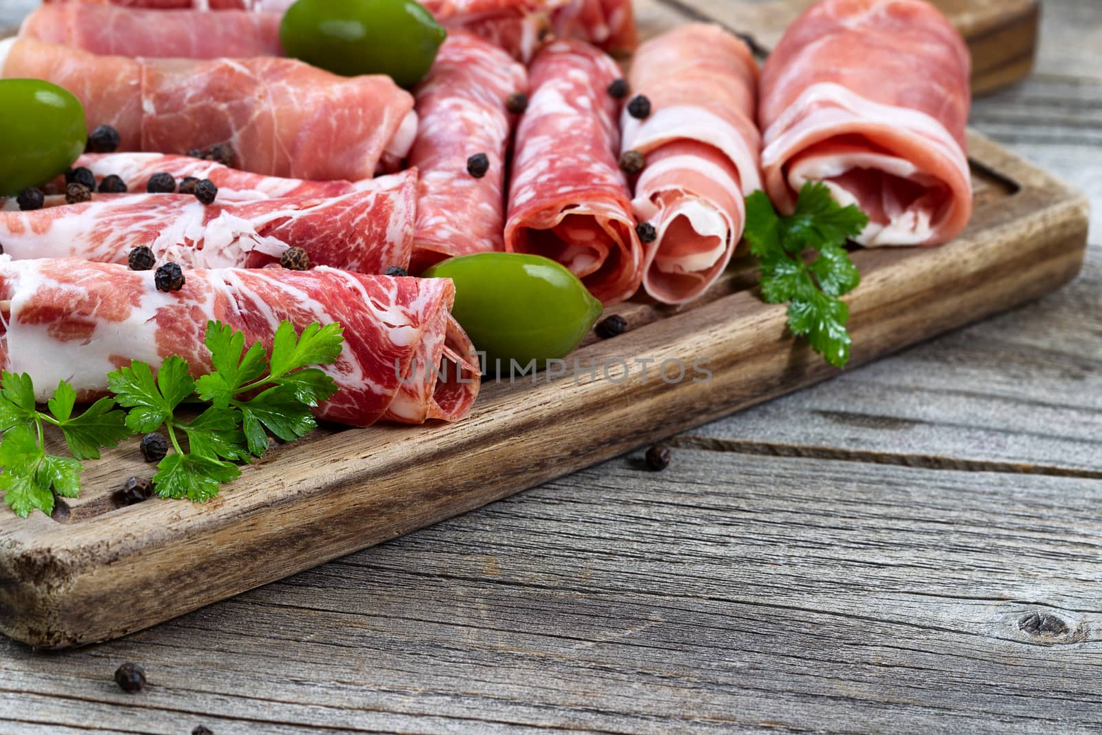 Various raw meats on serving board with rustic background  by tab1962
