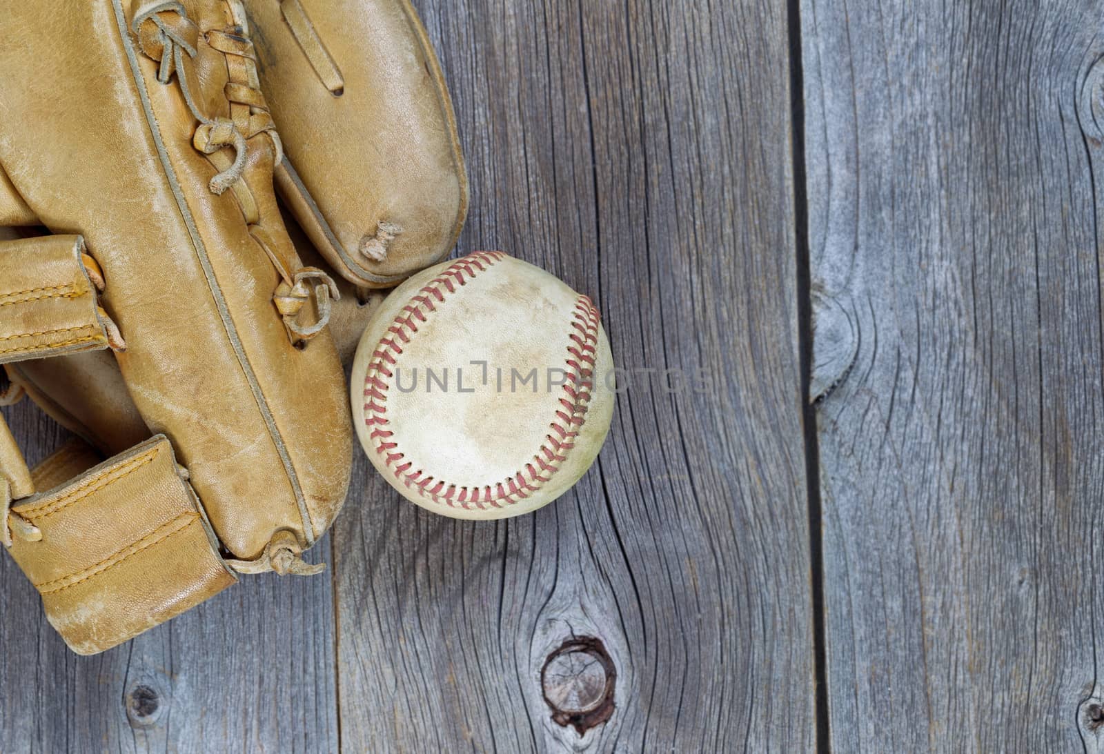 Used Baseball and Worn Glove on old wood  by tab1962