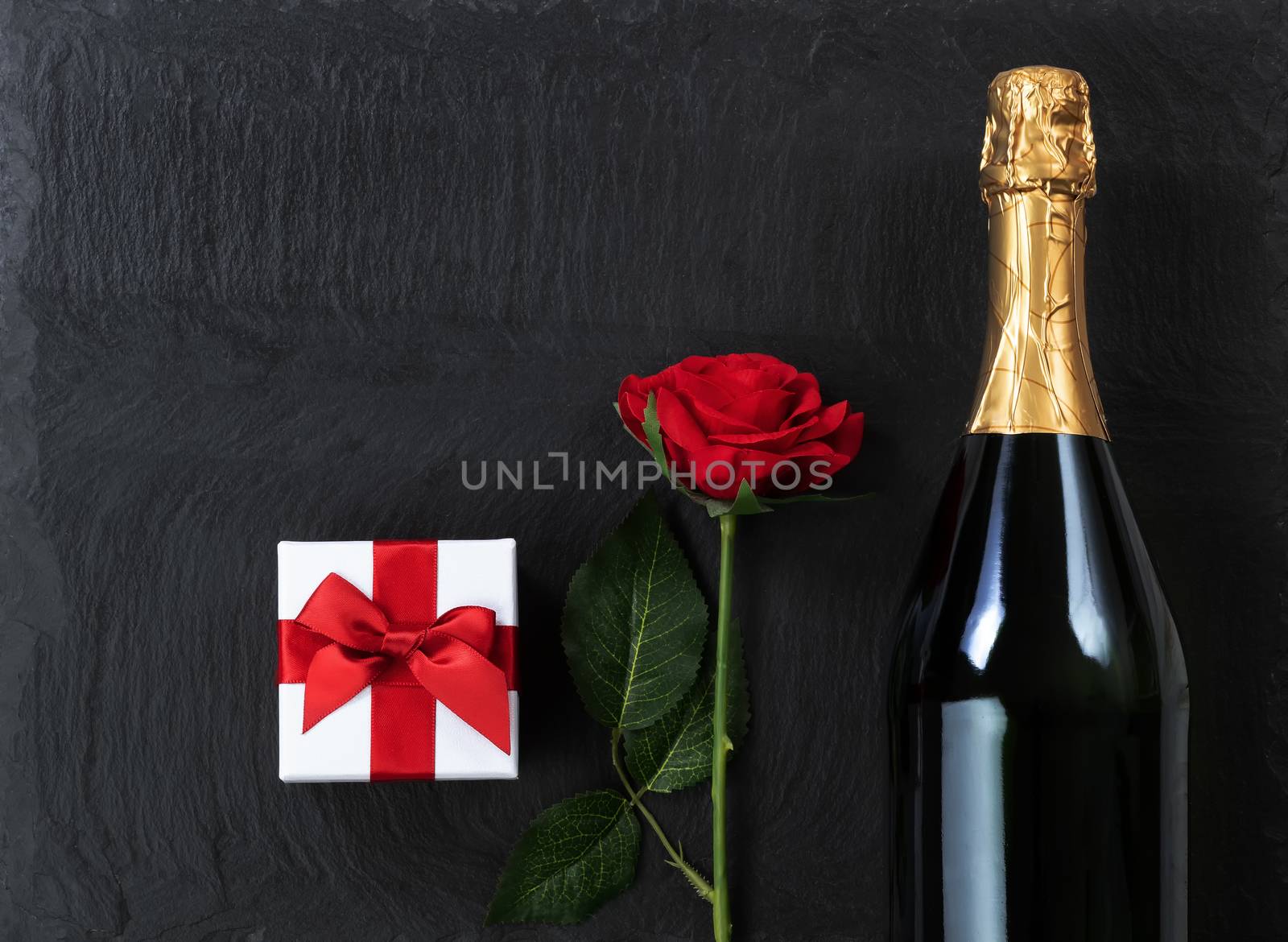 Anniversary background with champagne and gifts on natural slate by tab1962