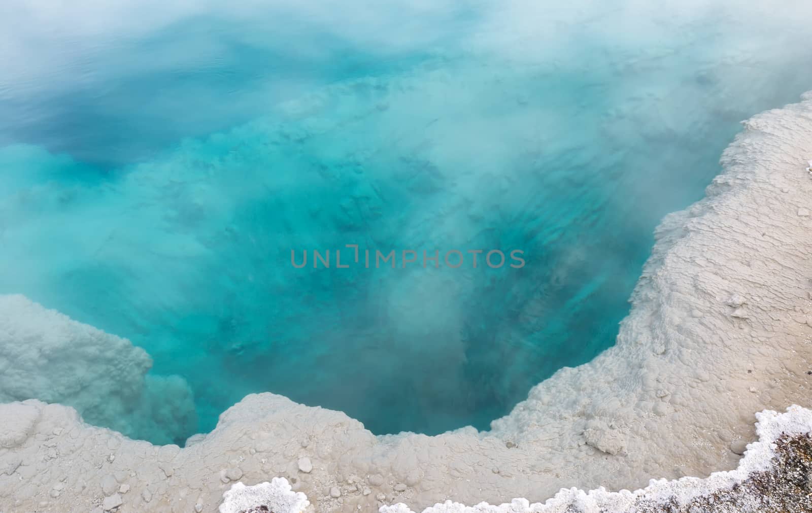 Closeup horizontal image of a deep aqua color hot spring hole in Yellowstone National Park 