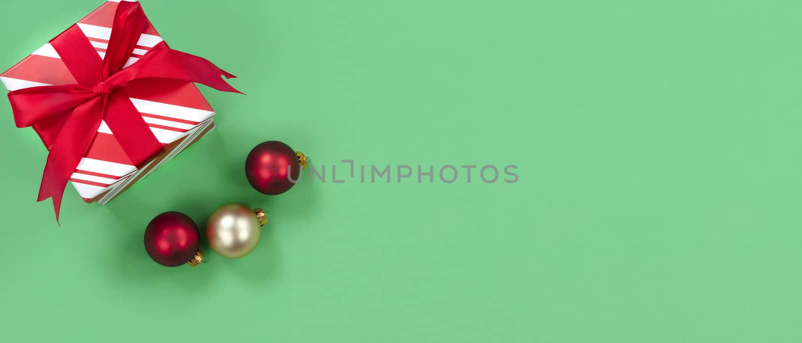 Green background with gift box and ornaments for the Christmas season 