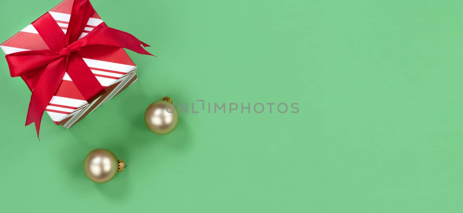 Green background with gift box and golden ornaments for the Christmas season 
