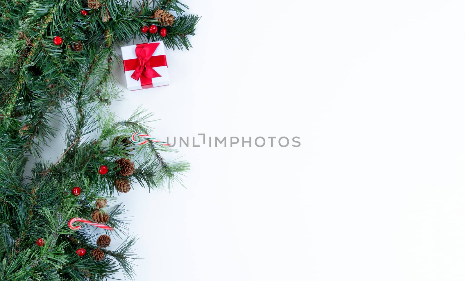 Christmas tree branches and decorations on left side of solid wh by tab1962
