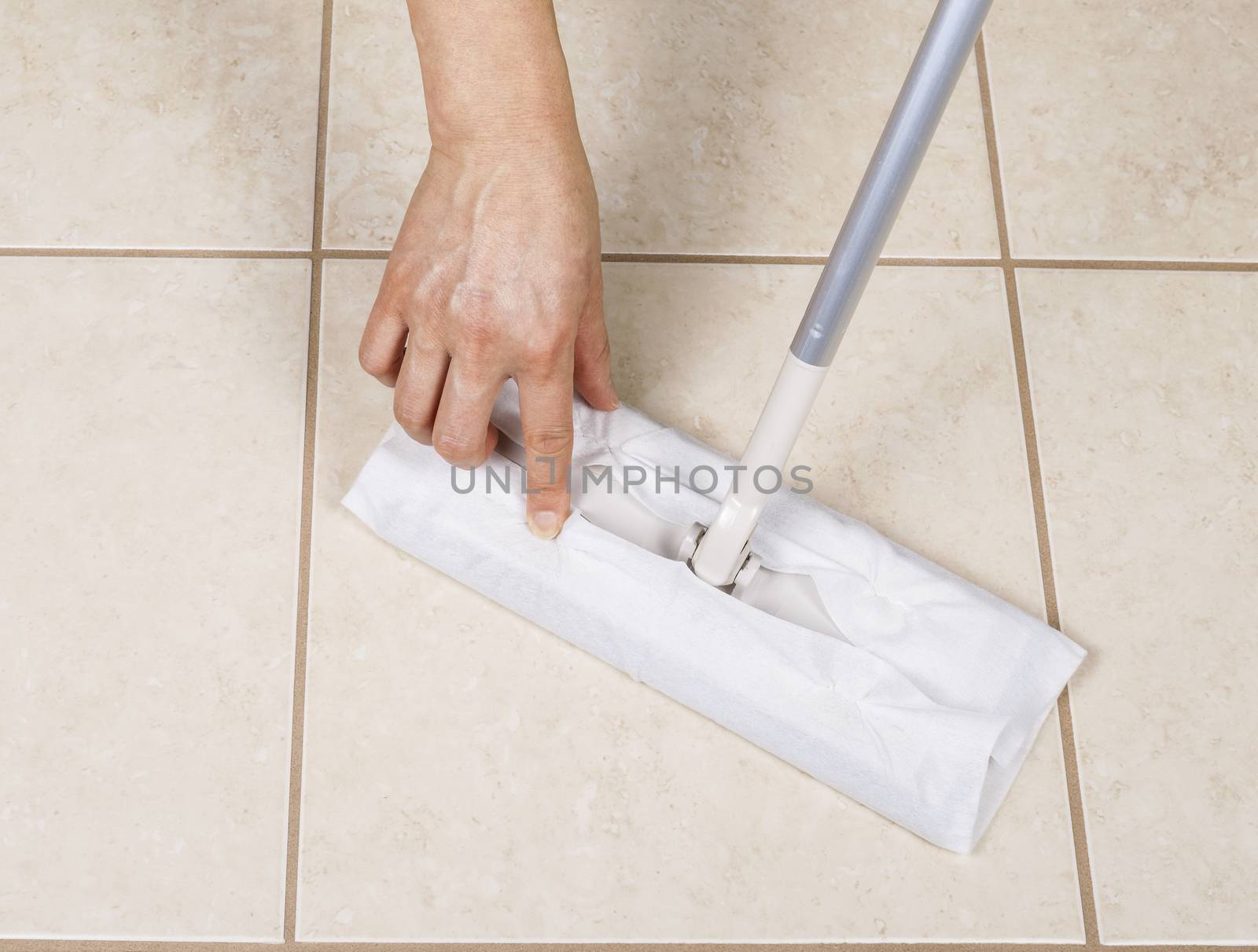 Hand placing paper wiper on cleaning broom for bathroom tile sweep 