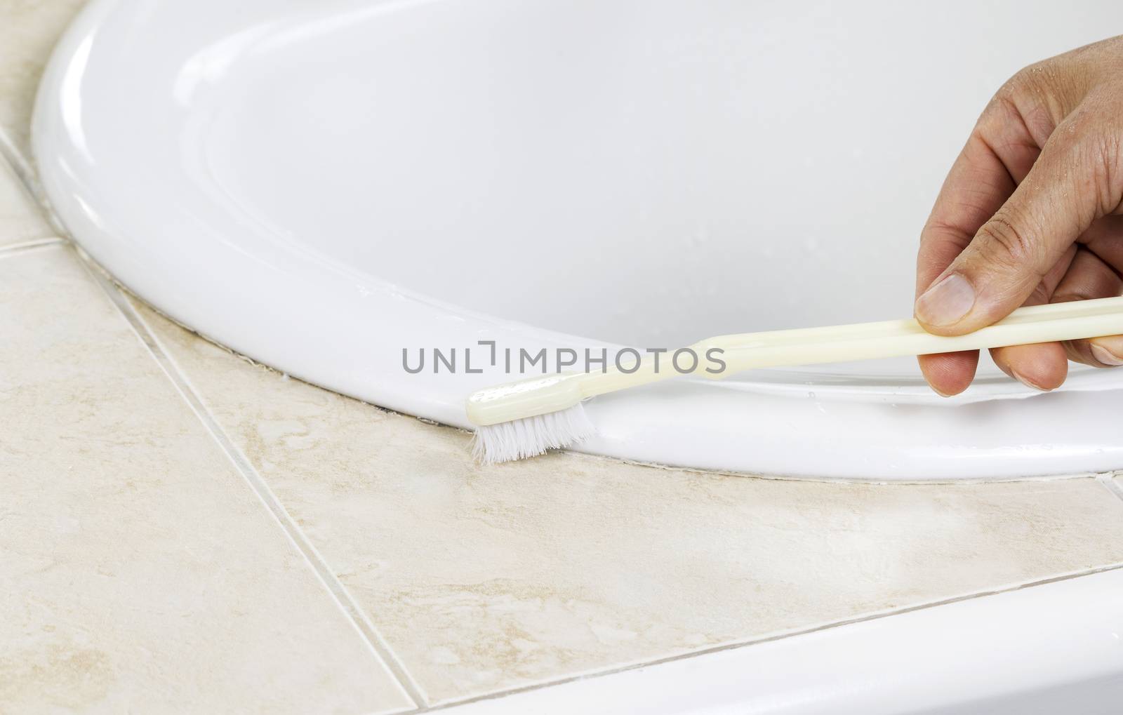 Cleaning Bathroom Sink with Tooth Brush  by tab1962