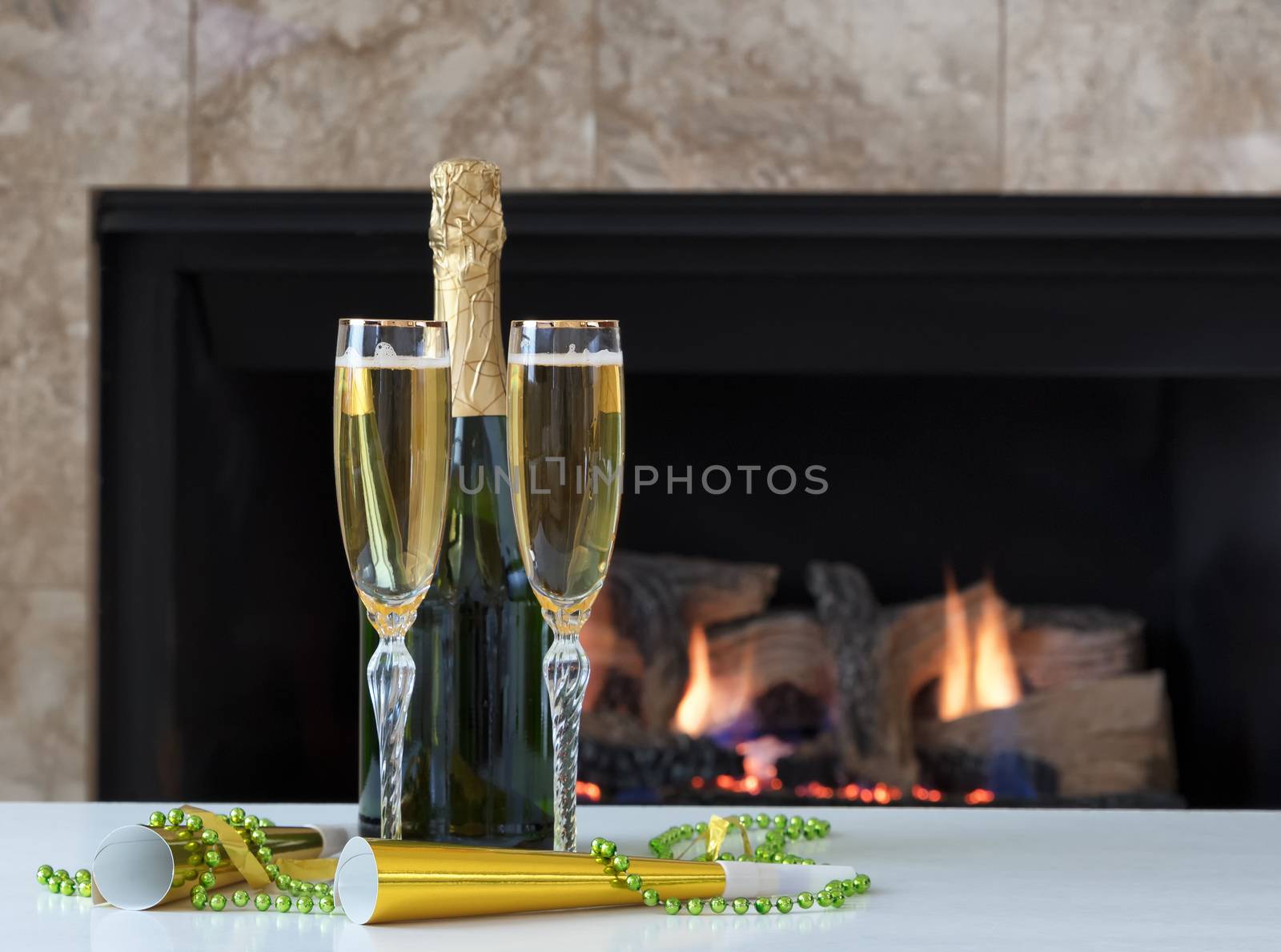 Happy New Year Celebration with golden champagne and glowing fireplace in background