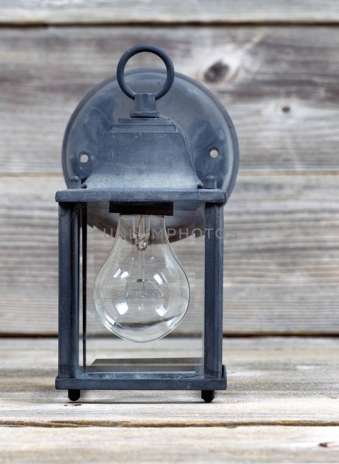 Vertical image of old outdoor light on rustic wooden boards