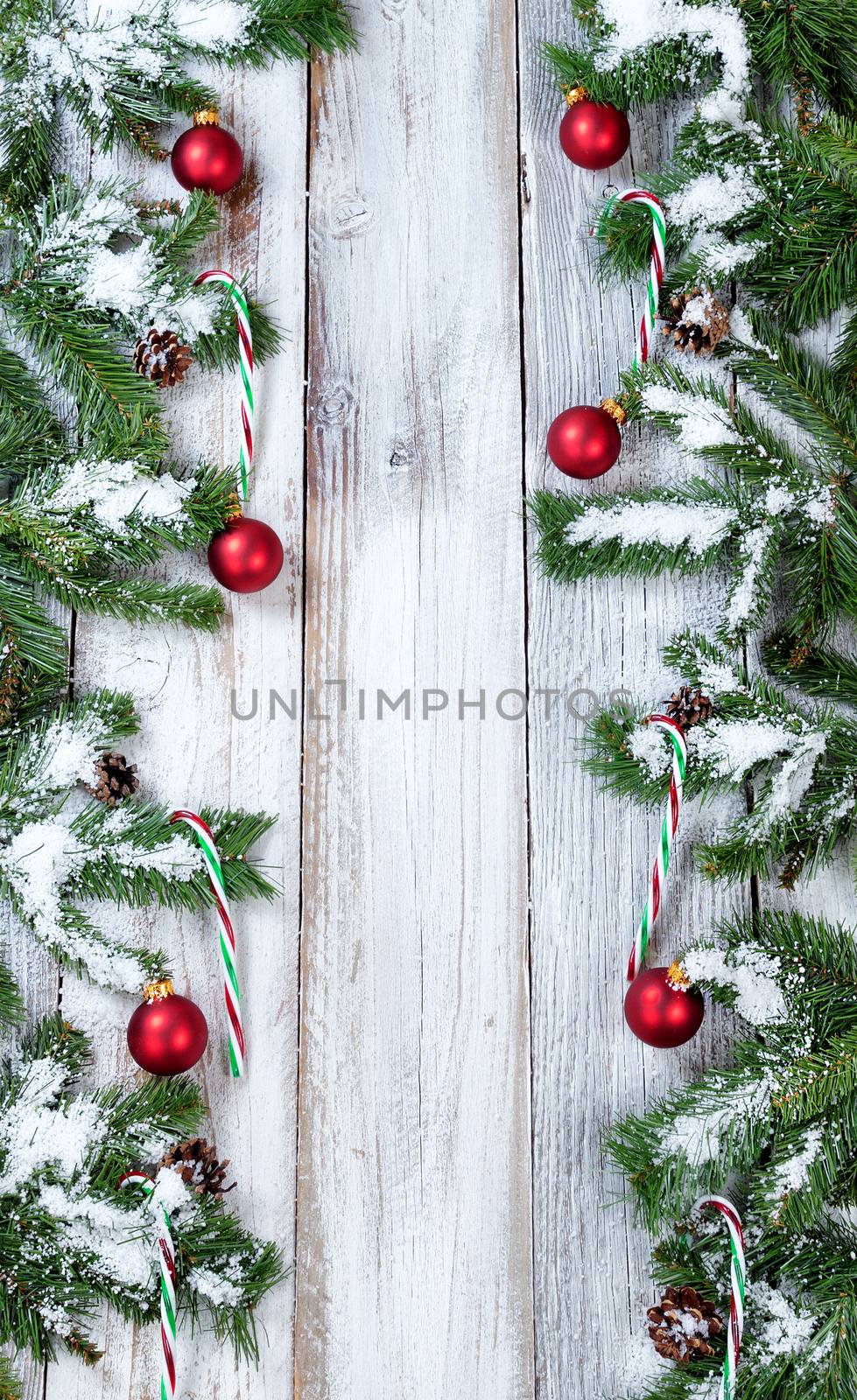 Vertical borders of snowy Christmas red ornaments and candy cane by tab1962