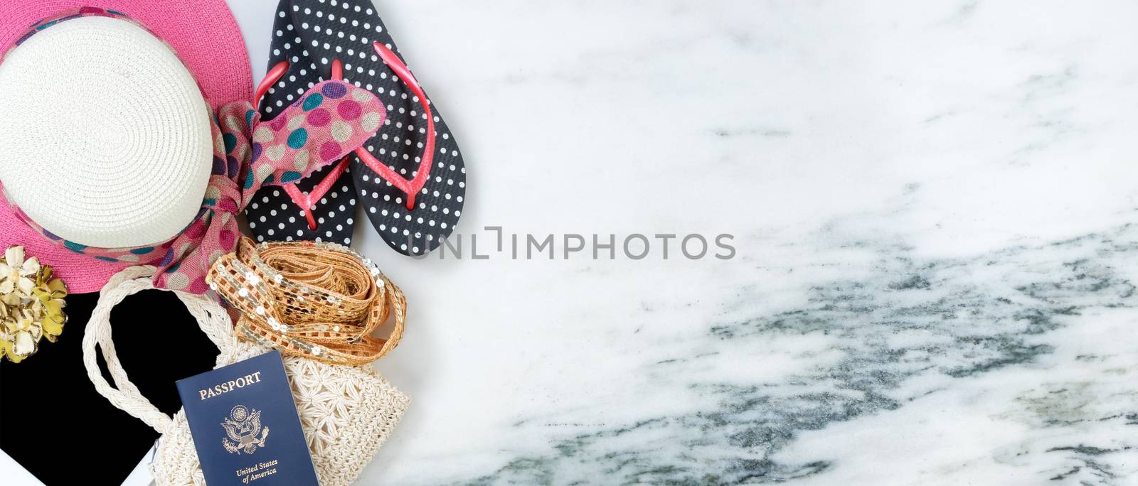 Women travel clothes with passport on marble stone forming left border in overhead view 