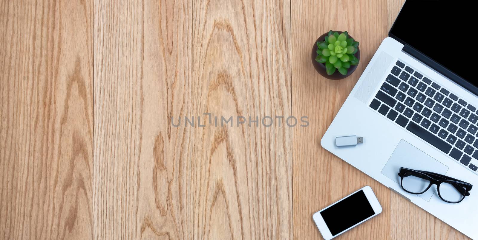 Overhead view of basic mobile office technology on wooden desktop  