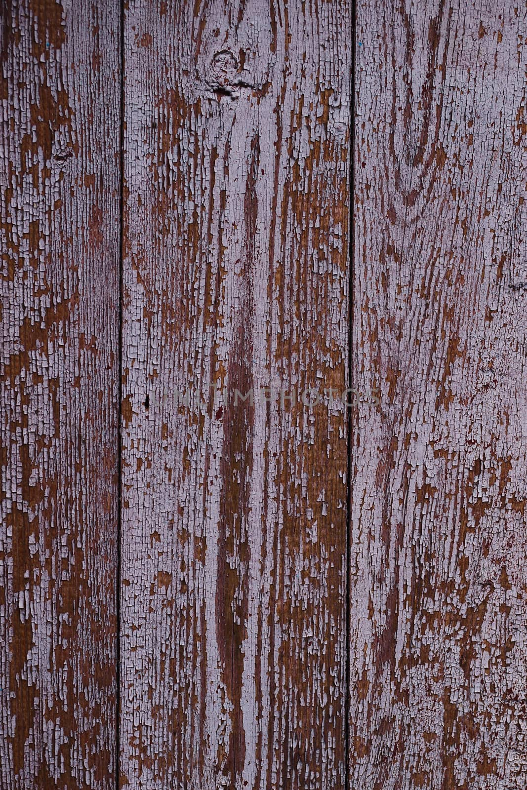 Old red wooden texured door surface closeup. Relief on surface. Stock photo of old wooden door pattern of aged boards with scratches. Red and gray colors on photo.