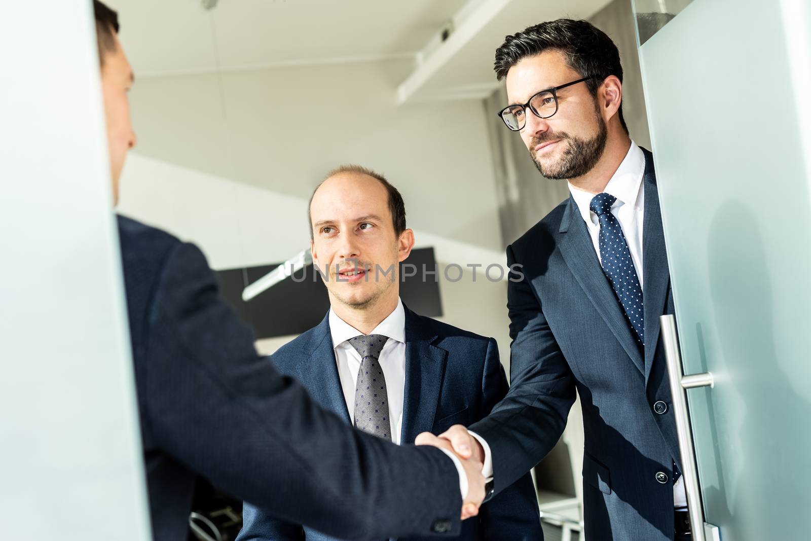 Group of confident business people greeting with a handshake at business meeting in modern office. Closing the deal agreement by shaking hands. Business and entrepreneurship success concept.