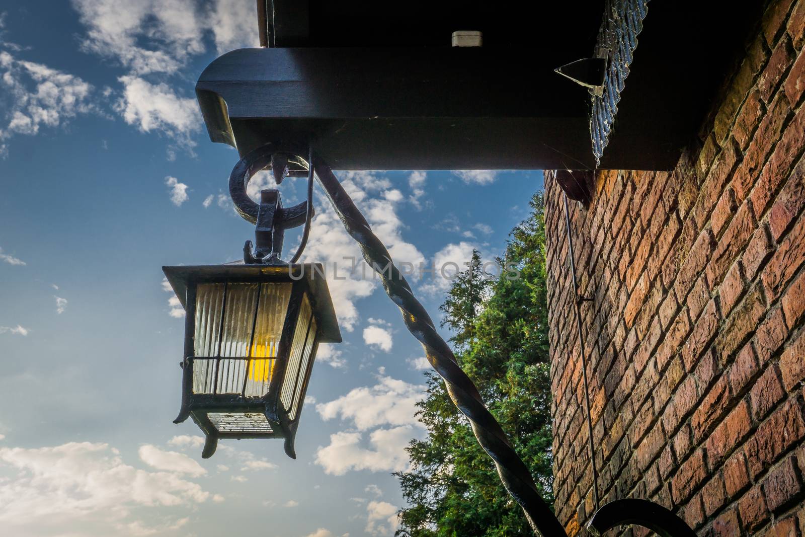 vintage old medieval looking street lantern hanging on the wall by charlottebleijenberg
