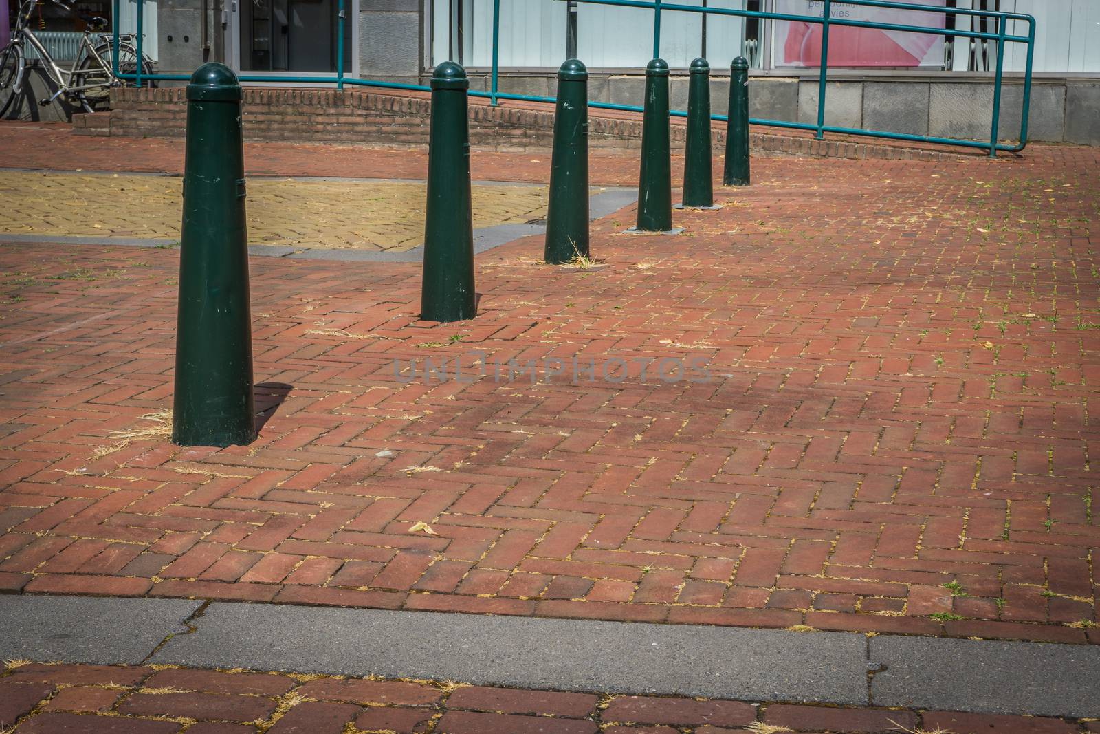 city landscape road with green poles and pattern pavement