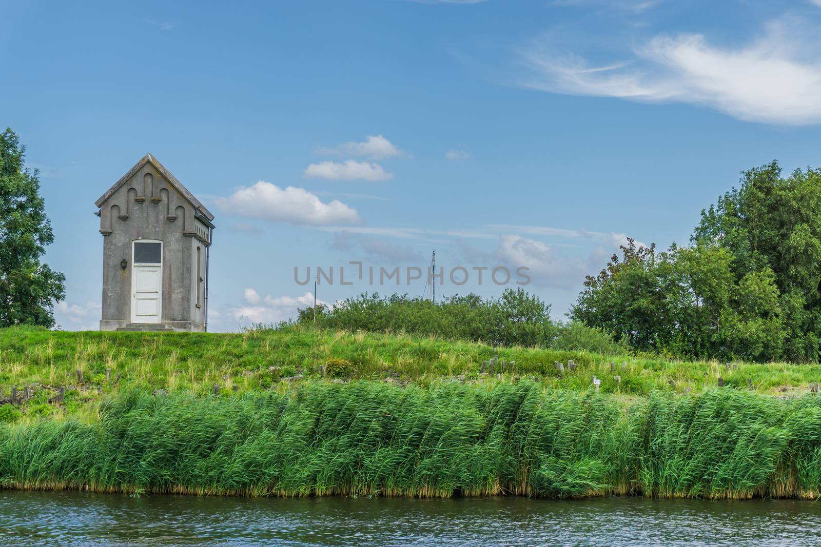 small cottage looking like a crypt at the lake in a water landscape distance view