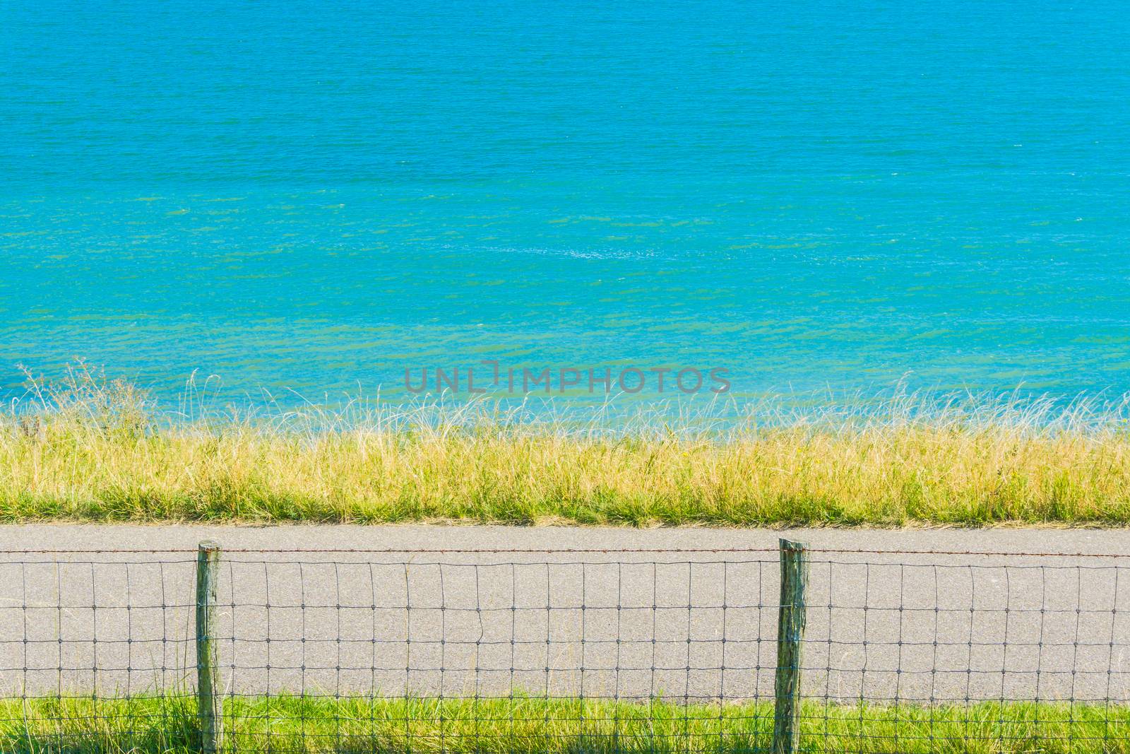 Water lake landscape with fence and road