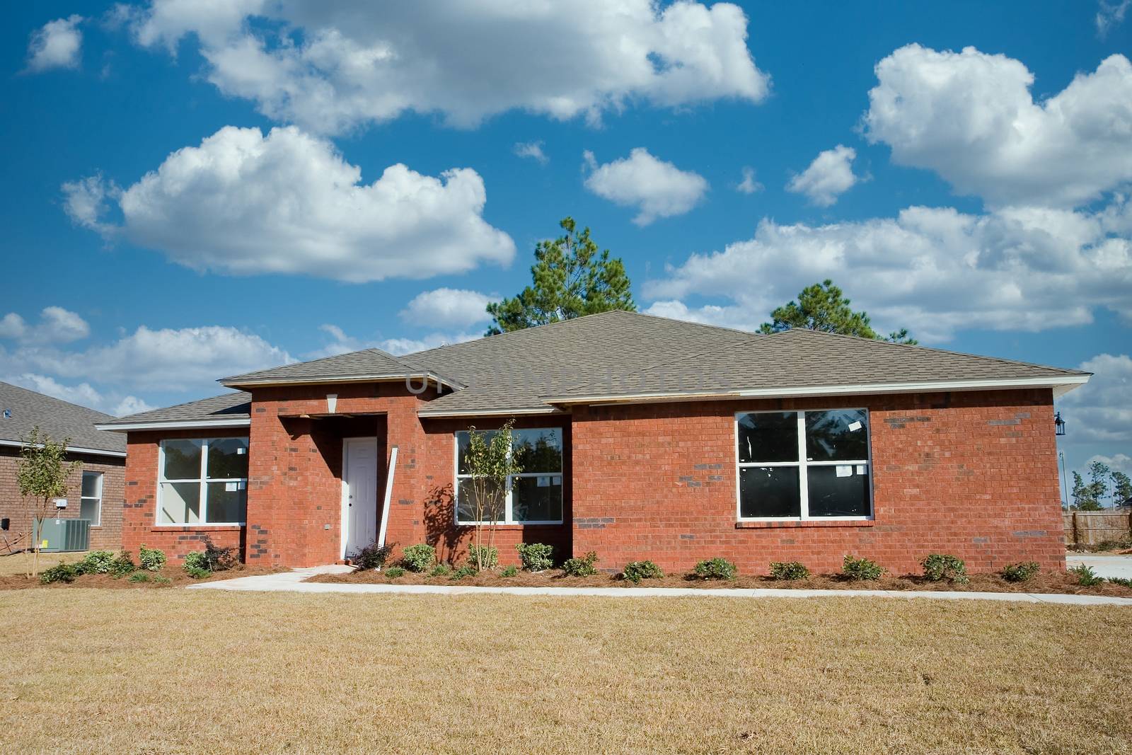 A new brick home under construction on a lot against sky