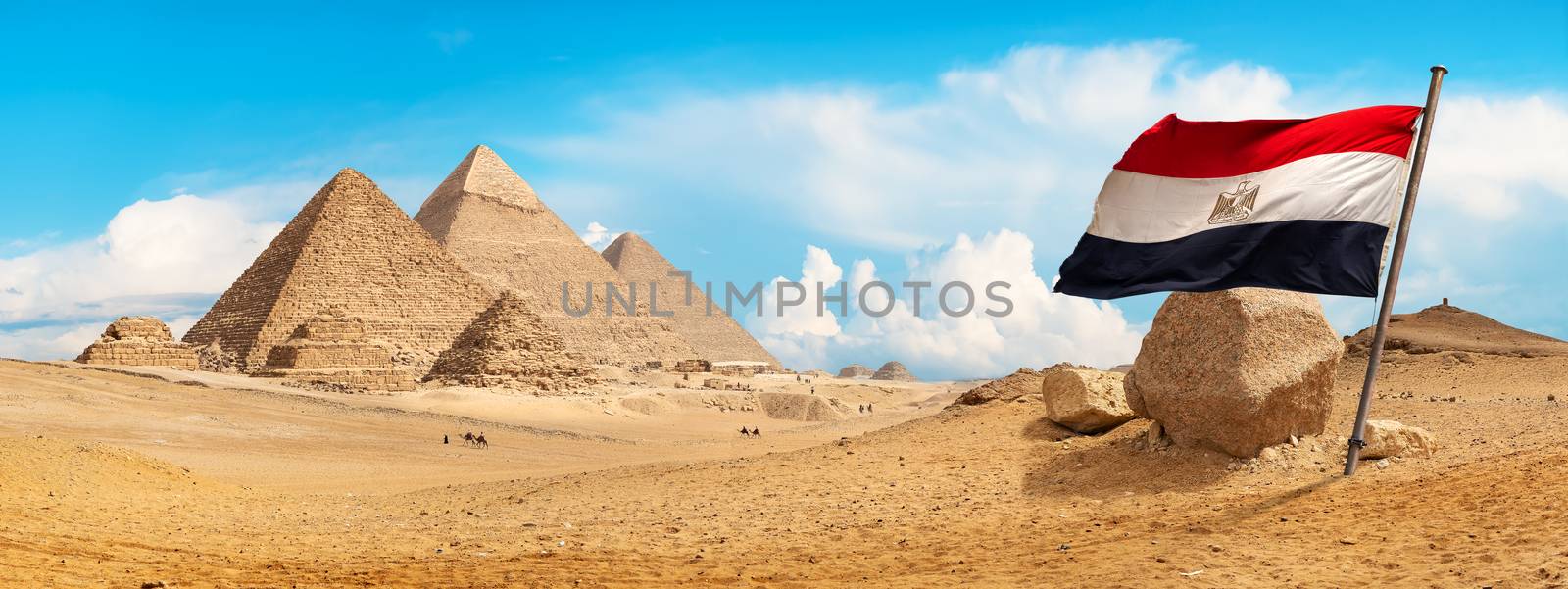 Pyramids of Giza in the desert and flag