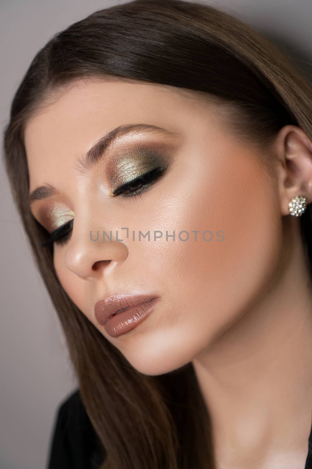 Beautiful young woman with perfect clean skin, bright shiny emerald makeup by natali_brill