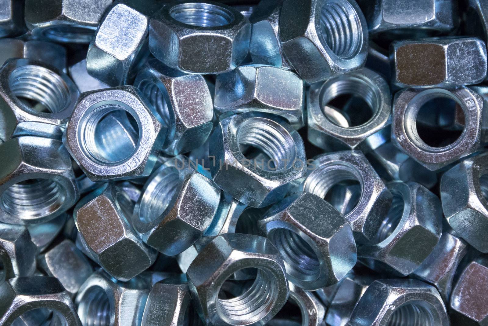 A pile of galvanized industrial nuts. Metal nut texture, industrial background. Macro photo. by petrsvoboda91
