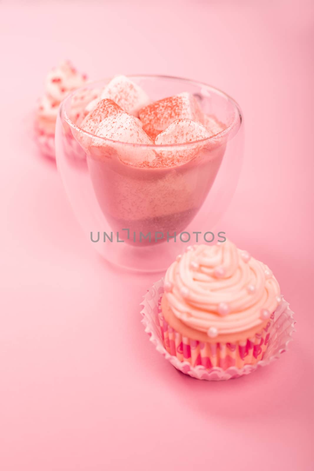 Valentine day love cupcake decorated with cream and hot chocolate on pink background with copy space for text