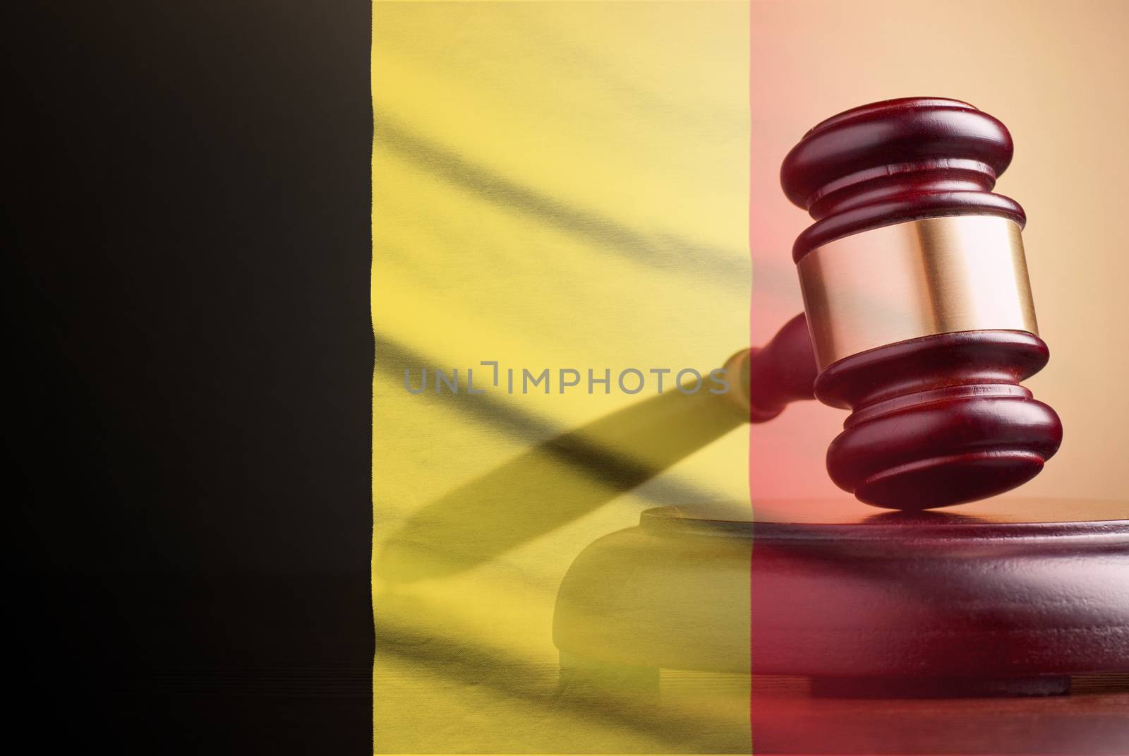 Lawyers wooden gavel resting on its plinth over the flag of Belgium in a concept of the courts, legality and law and order