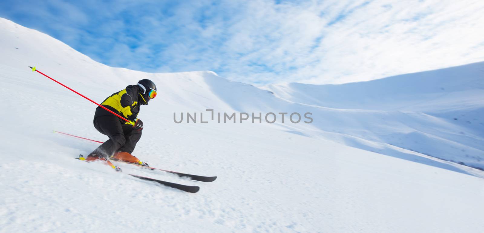 Alpine skier skiing downhill in high mountains, professional gs ski, copy space for text