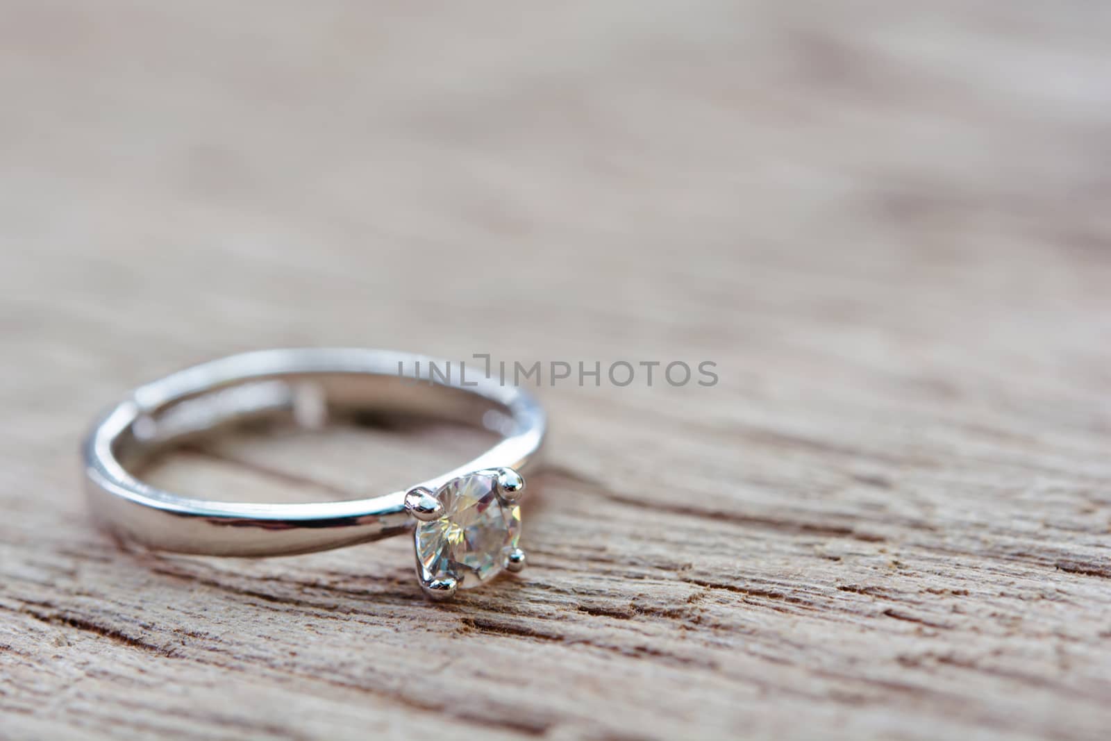 Diamond ring, wedding ring on plank wooden with copy space 
 by sunnygb5