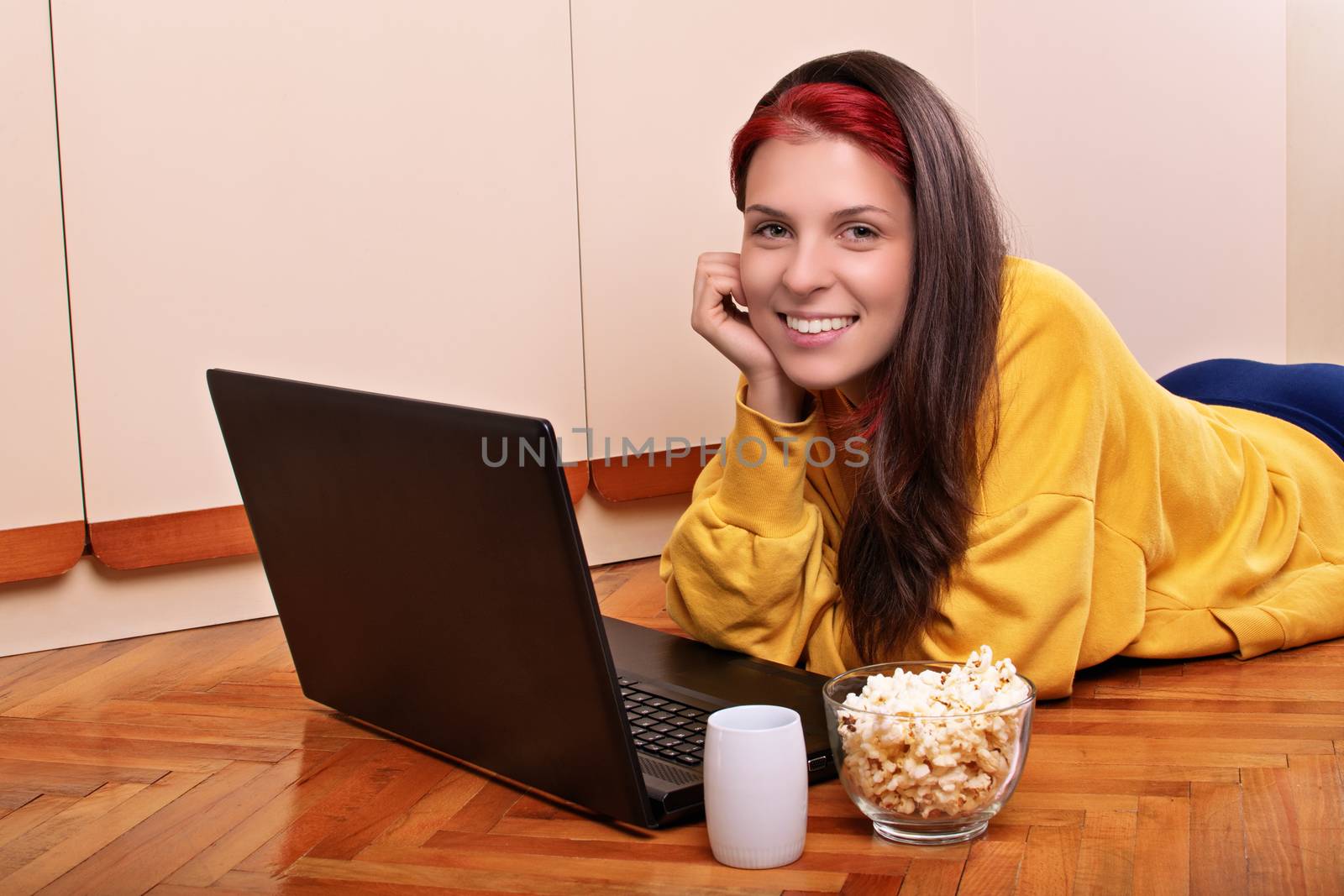 Young girl ready to watch a movie with popcorn and cup of warm d by Mendelex