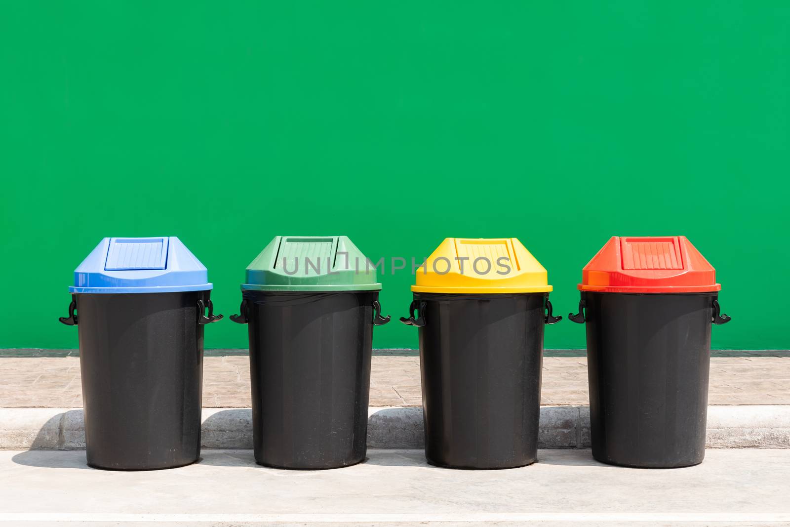 Blue green yellow red color plastic recycle bin outdoor for waste on concrete floor 