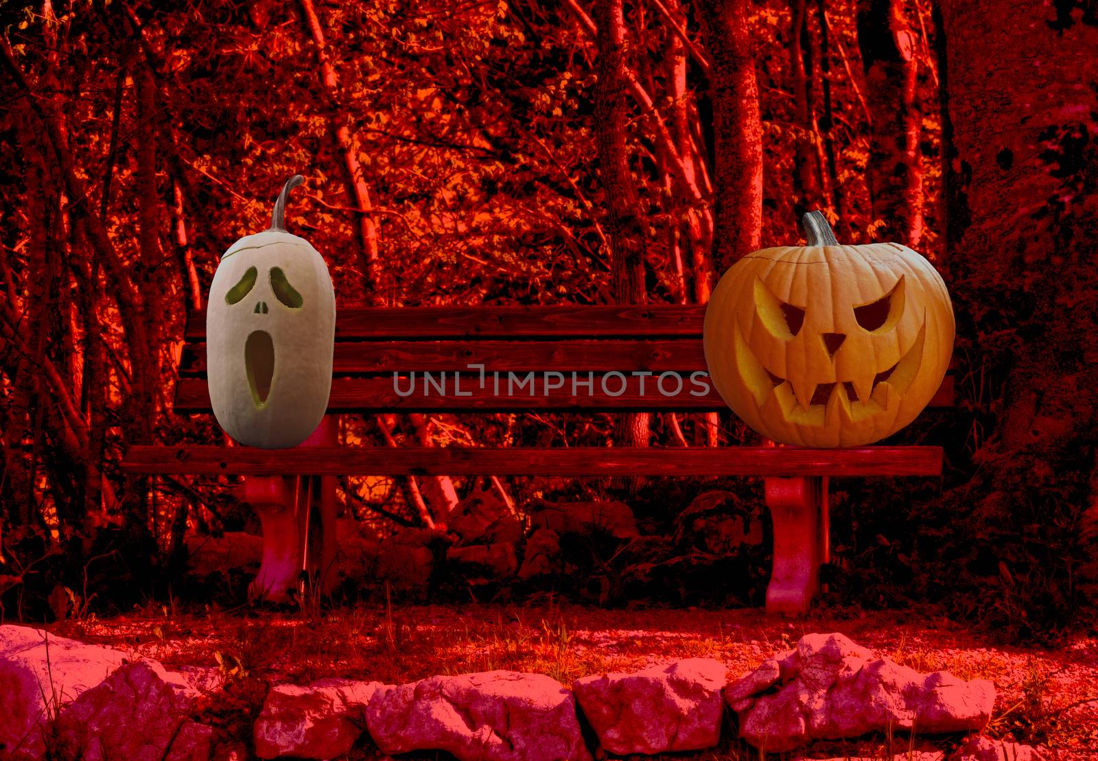 Halloween celebration two scary and spooky carved pumpkins on a park bench in a horror forest landscape