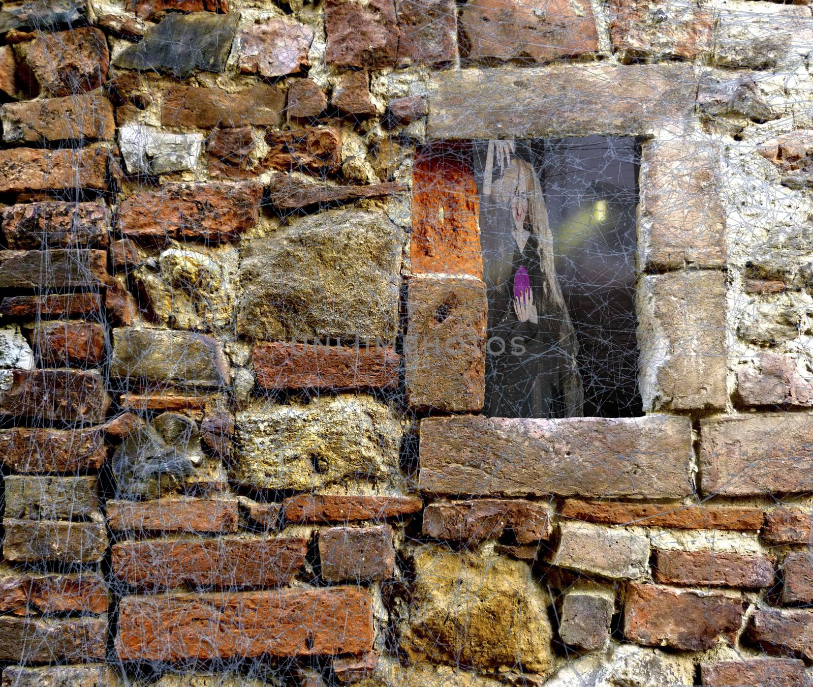 Halloween scary Witch and ghost forest with cabin through a window of a brick stone wall covered in spider web rags