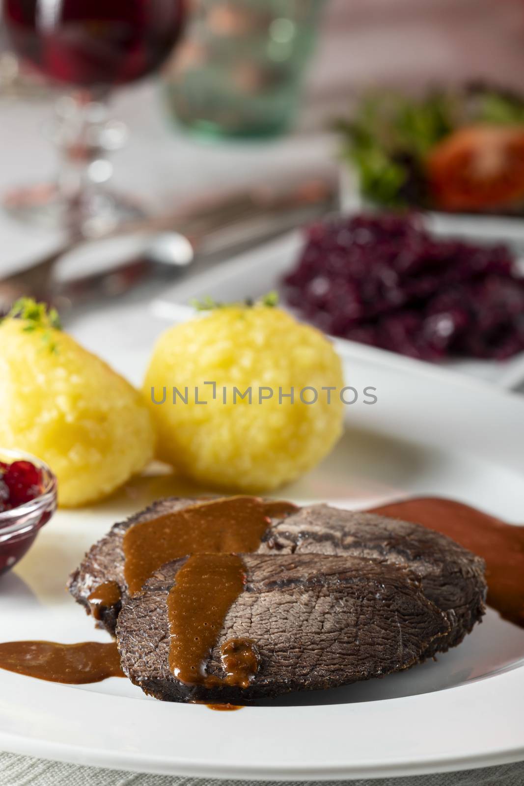 closeup of a german sauerbraten with dumplings by bernjuer