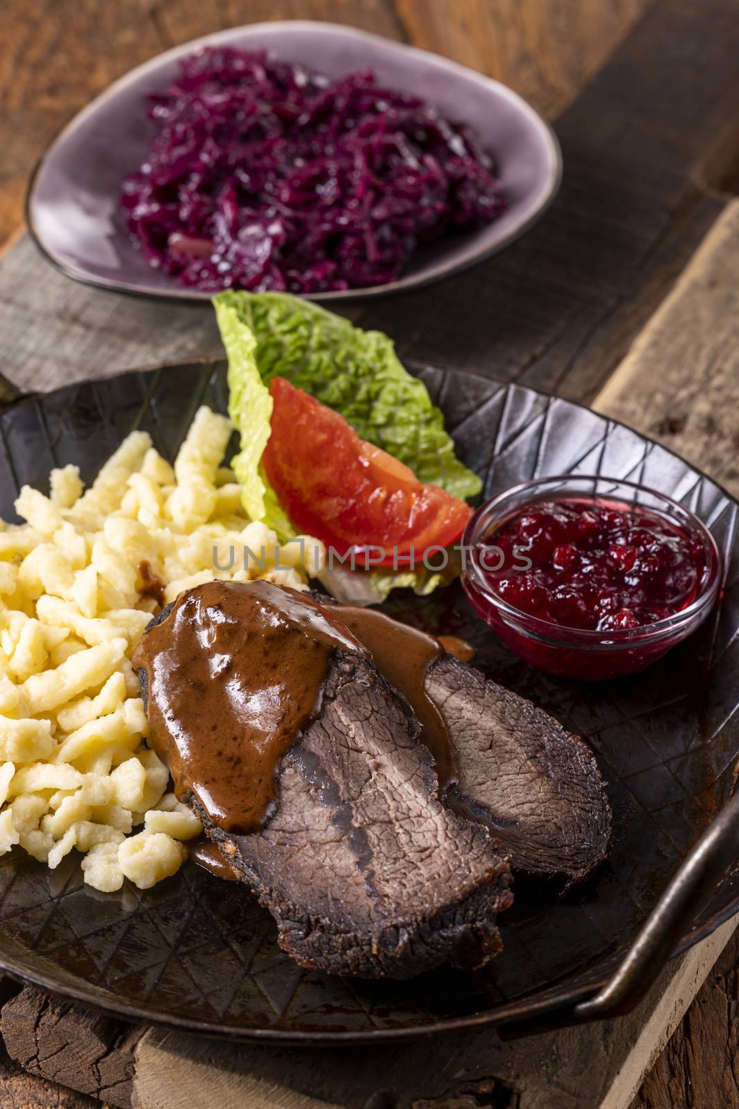 closeup of a german sauerbraten with dumplings by bernjuer