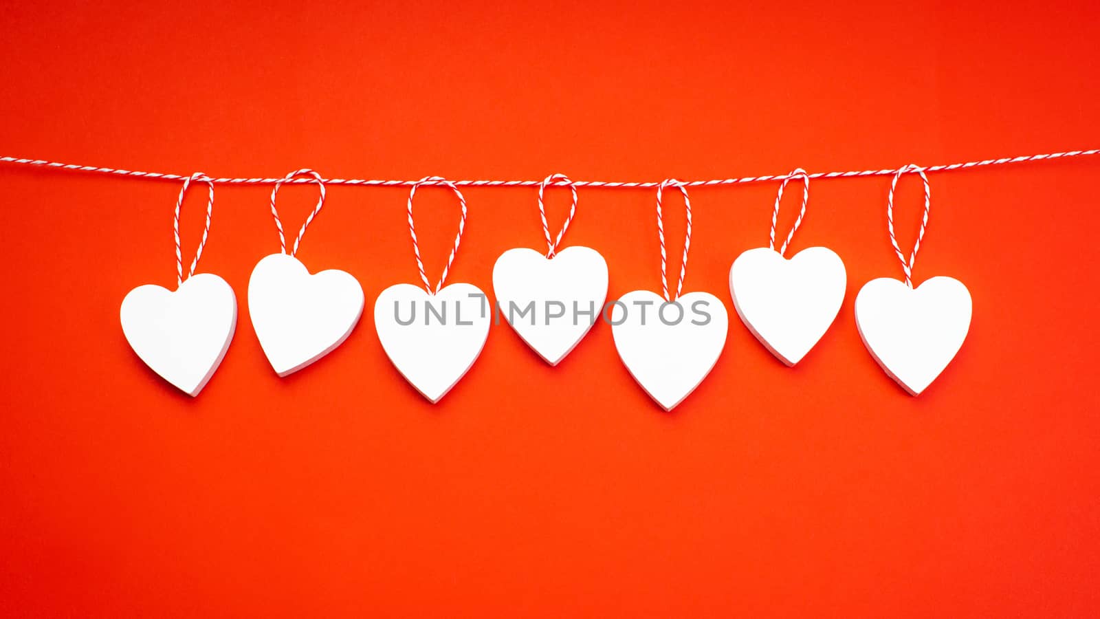 Valentine's Day. White wooden hearts on a red background. Blank for the designer. by nkooume