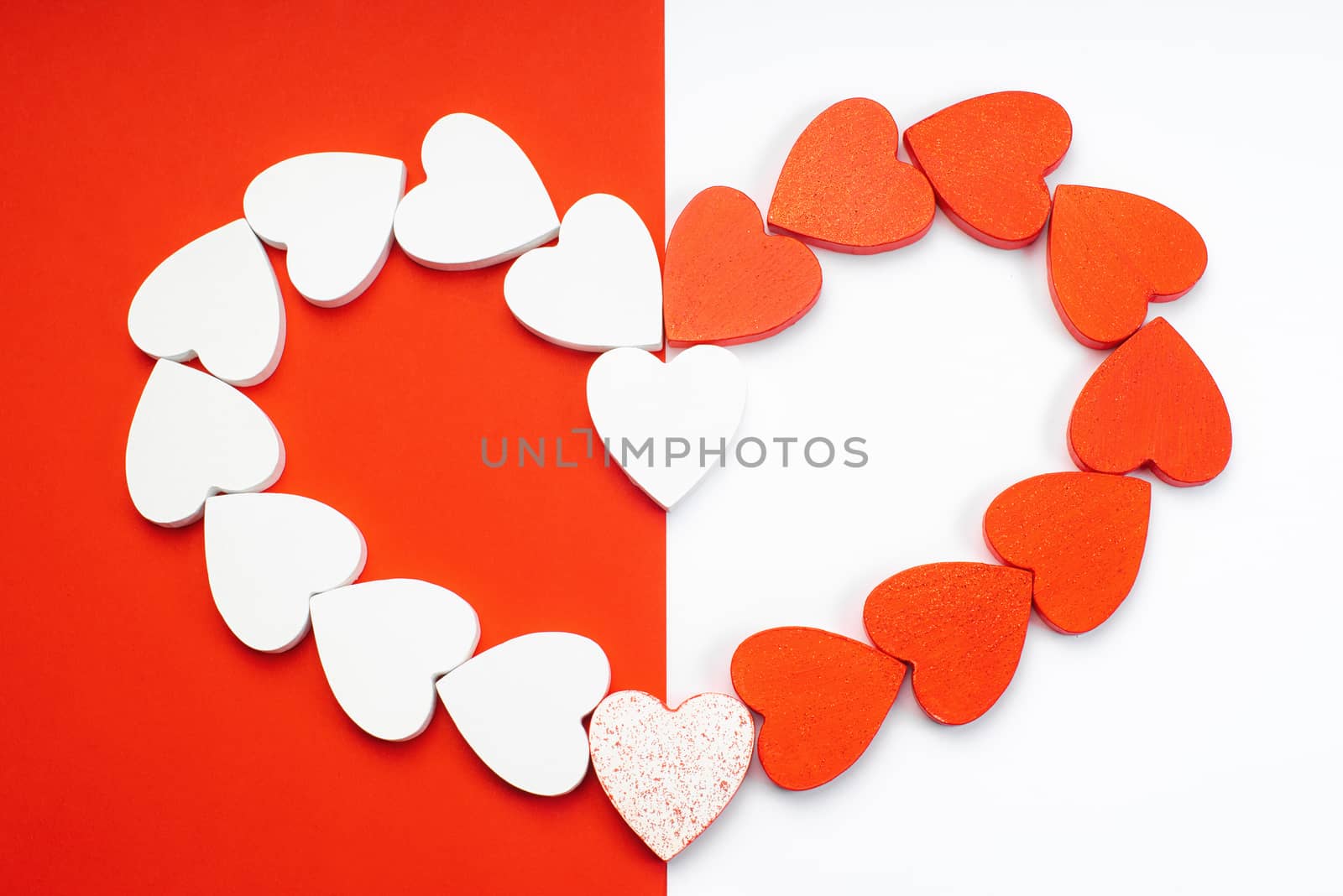 White and red wooden hearts on a red and white background. Blank for the designer. Valentines day concept. Greeting card. Valentine's Day. Copy space.