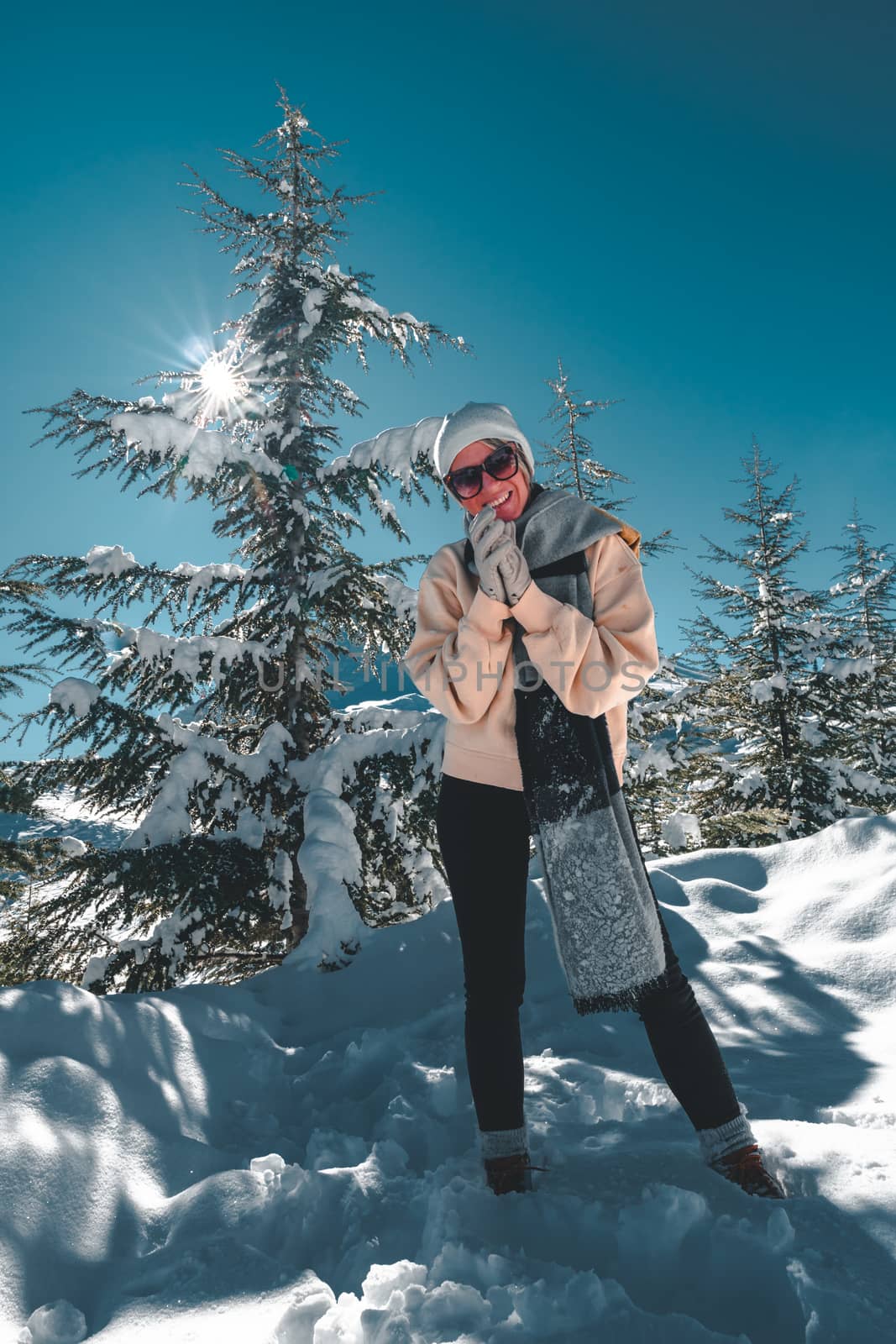Happy adult woman posing with blue sky and the sun n the background.