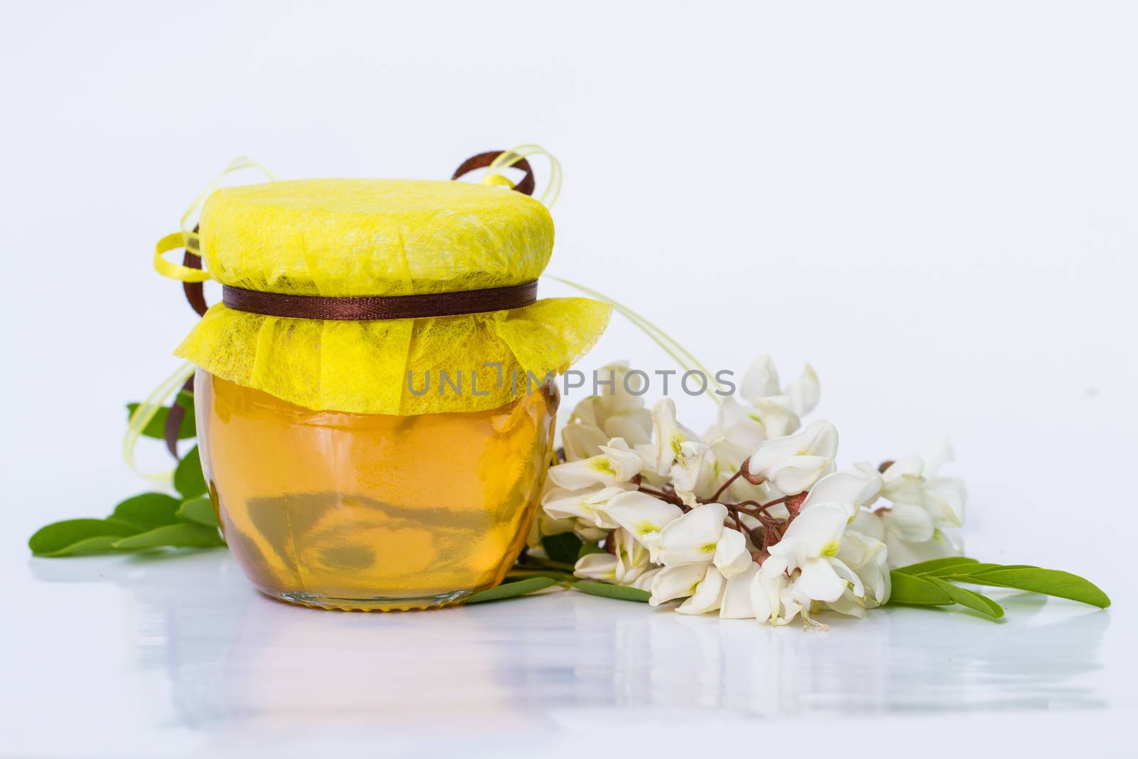 Acacia honey on white background. Robinia pseudoacacia