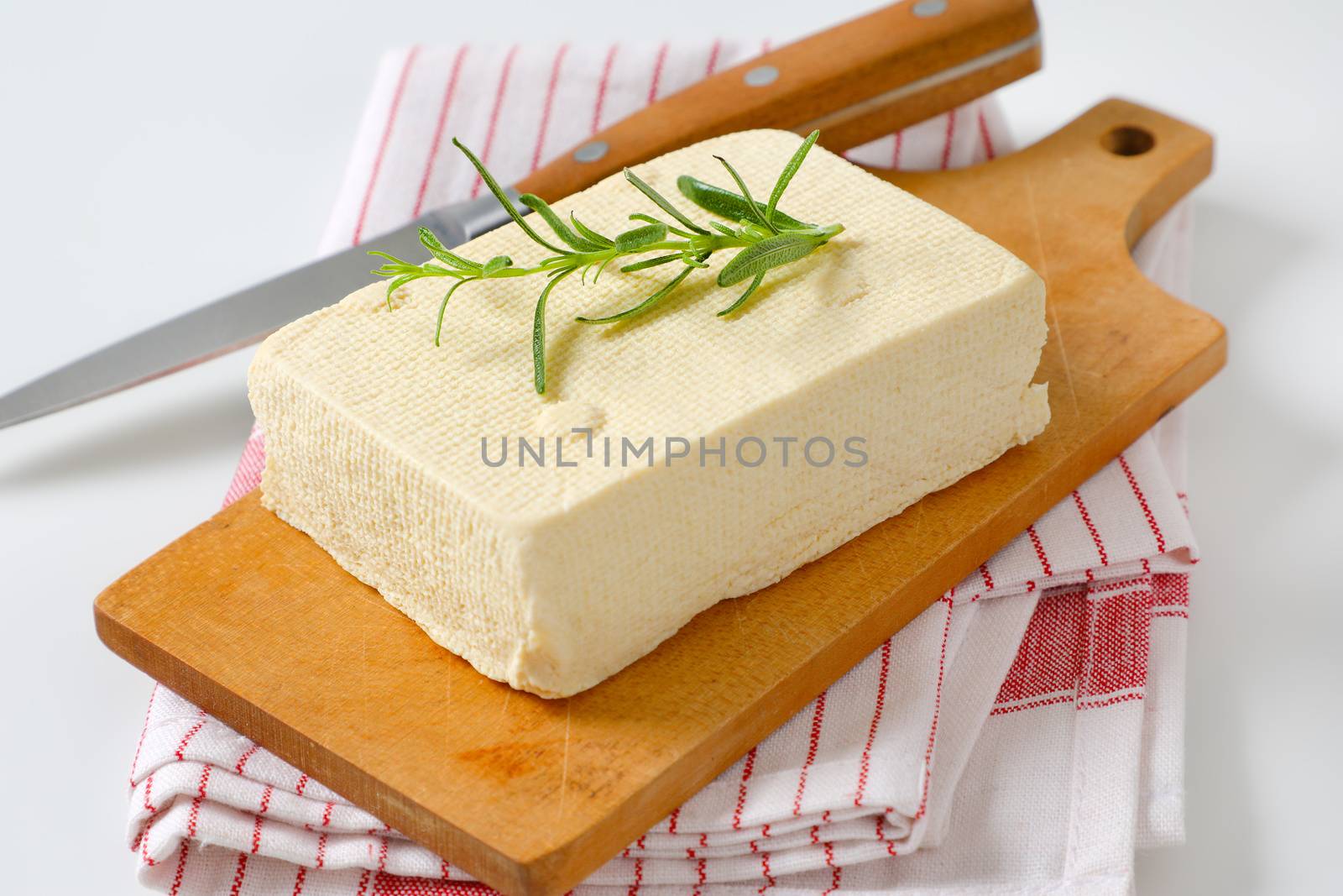 Block of fresh bean curd (tofu) on cutting board