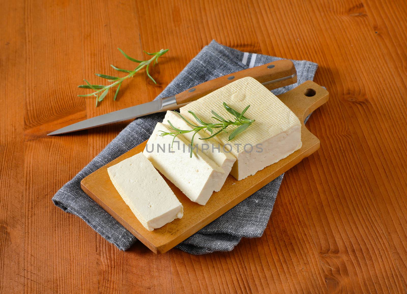 Sliced block of fresh bean curd (tofu) on cutting board